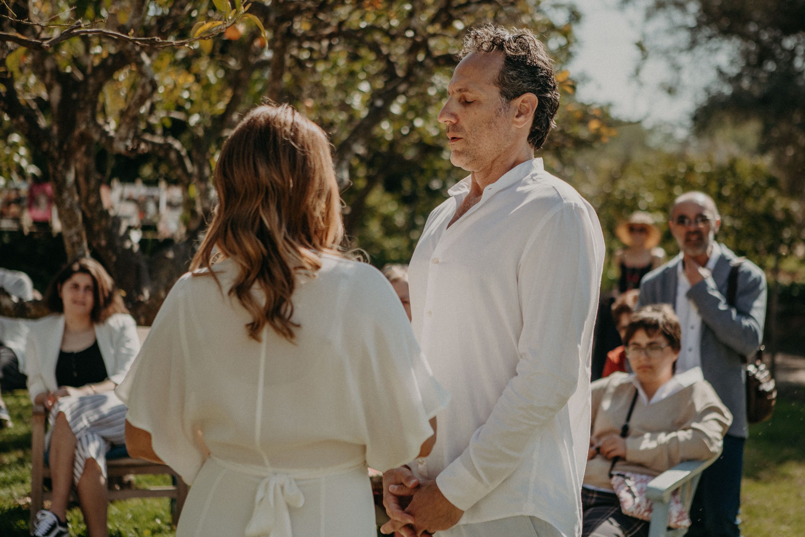 groom with eyes closed during wedding ceremony at a orange tree garden