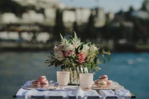 decoração de uma mesa junto ao rio em tons de pastel rosa verde e branco