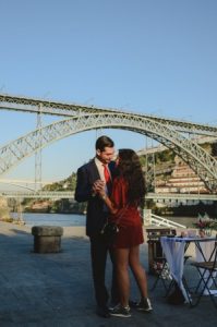 lovers dacing at ribeira do douro with D Luis bridge behind